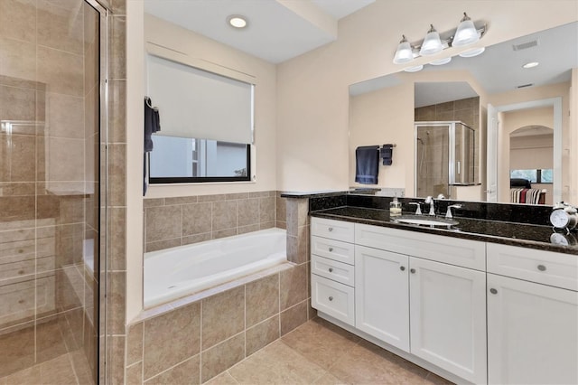 bathroom with tile patterned floors, vanity, and shower with separate bathtub