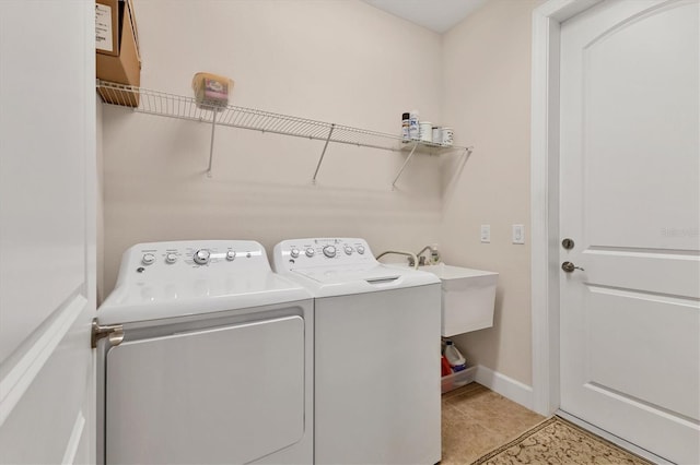 washroom with sink, light tile patterned floors, and washer and dryer