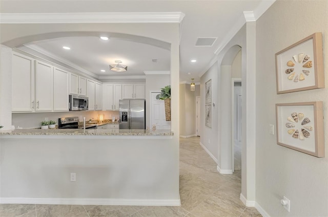 kitchen featuring white cabinets, crown molding, light stone countertops, and stainless steel appliances