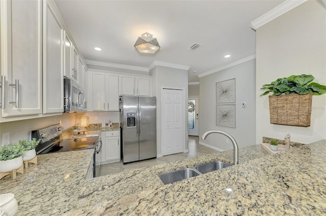 kitchen featuring white cabinetry, sink, stainless steel appliances, light stone counters, and ornamental molding