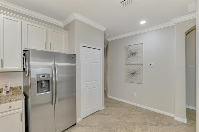 kitchen with light stone countertops, stainless steel refrigerator with ice dispenser, white cabinetry, and crown molding