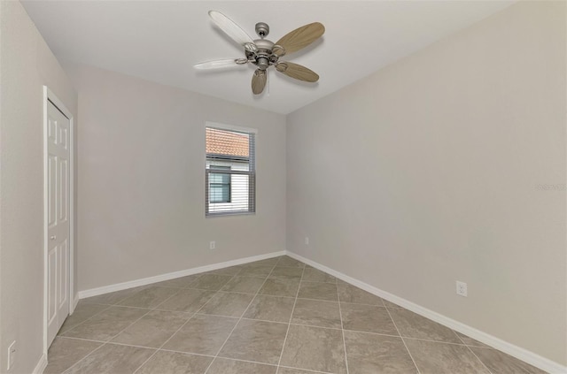 spare room with ceiling fan and light tile patterned flooring