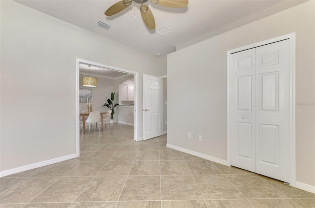 spare room with ceiling fan and light tile patterned flooring