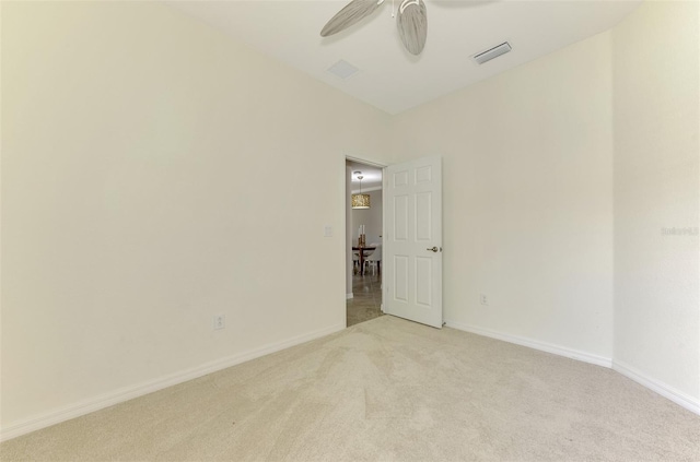 unfurnished room featuring light colored carpet and ceiling fan