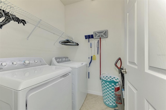 laundry area with light tile patterned floors and washing machine and clothes dryer