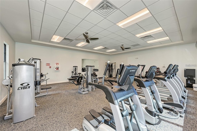 exercise room with a paneled ceiling, ceiling fan, and a tray ceiling