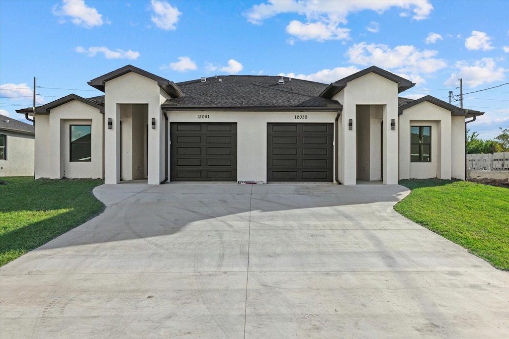 contemporary house featuring a front yard and a garage