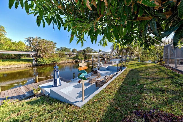 view of dock with a yard and a water view