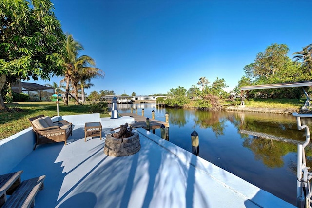 dock area featuring a water view and an outdoor living space with a fire pit