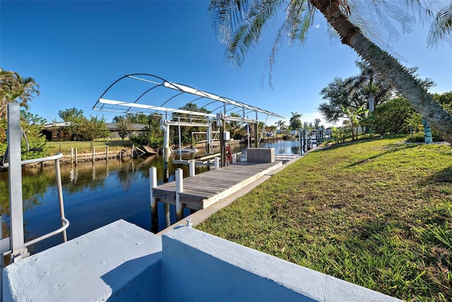 view of dock with a lawn and a water view