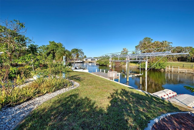 view of dock featuring a lawn and a water view