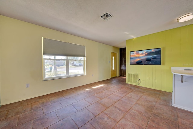 empty room featuring light tile patterned flooring and a textured ceiling