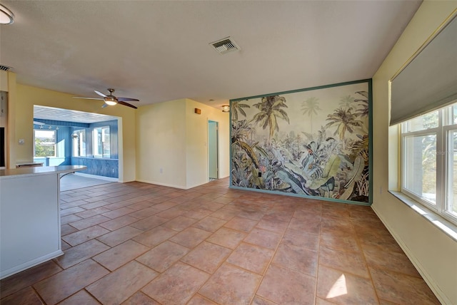 unfurnished living room featuring light tile patterned floors and ceiling fan