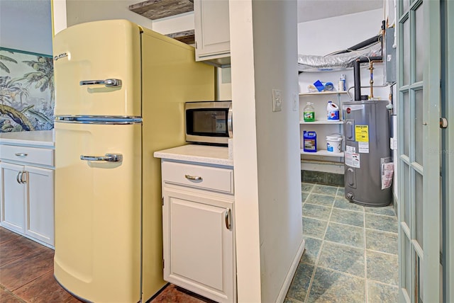 kitchen with white cabinets, white refrigerator, and water heater