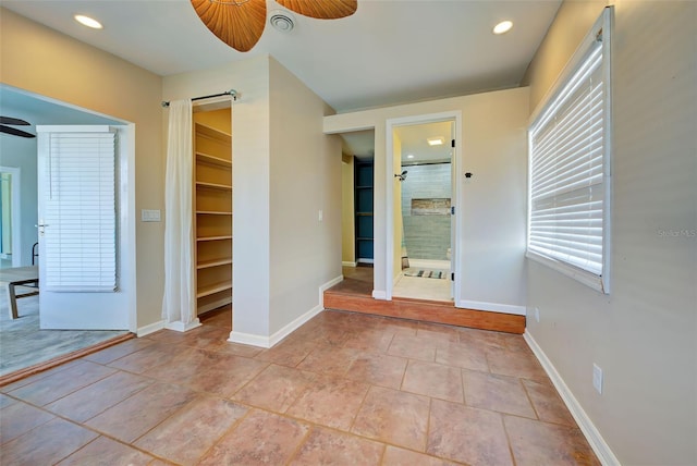 tiled spare room with ceiling fan