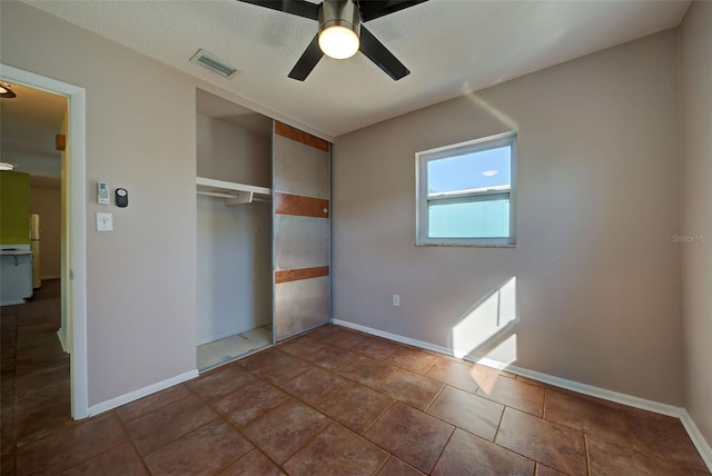 unfurnished bedroom with a closet, tile patterned floors, and ceiling fan