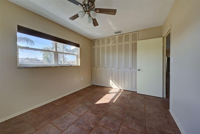 unfurnished bedroom with tile patterned floors and ceiling fan