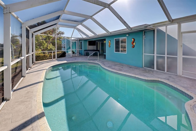 view of pool featuring glass enclosure and a patio area