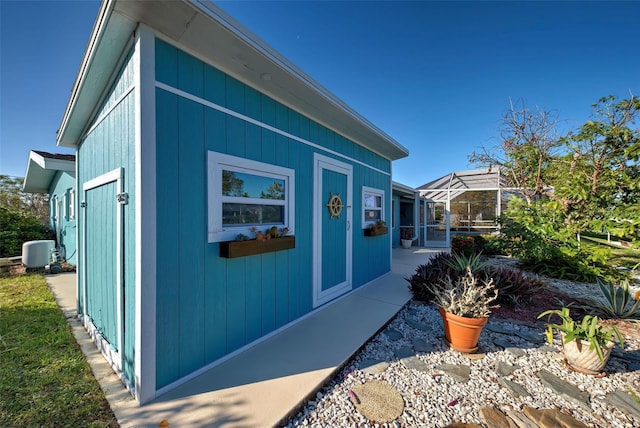 view of property exterior with glass enclosure