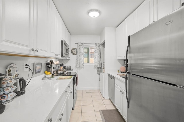 kitchen with light tile patterned floors, white cabinetry, and appliances with stainless steel finishes