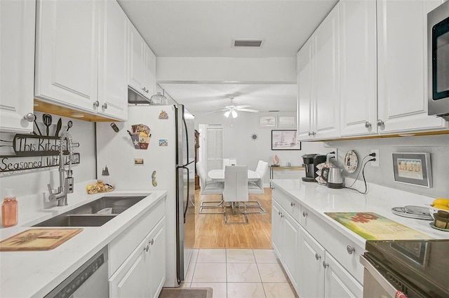 kitchen featuring white cabinets, ceiling fan, and sink