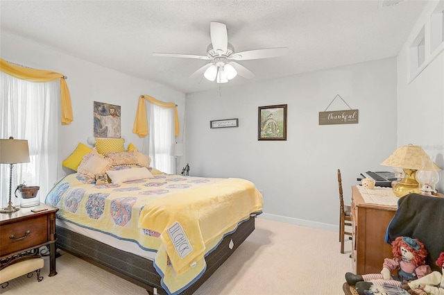 carpeted bedroom with ceiling fan and a textured ceiling