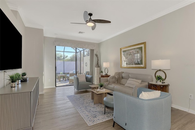 living room featuring ceiling fan, crown molding, and light wood-type flooring