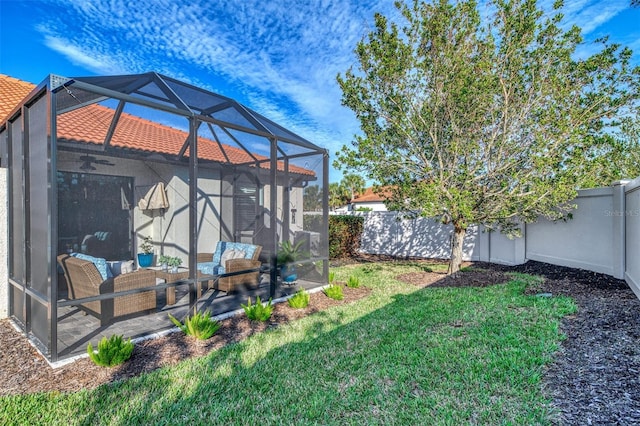 view of yard with glass enclosure and ceiling fan