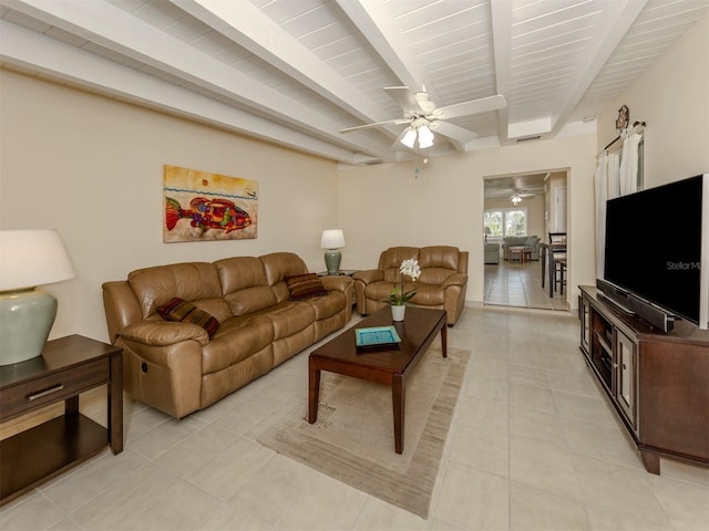 living room with beamed ceiling and light tile patterned flooring