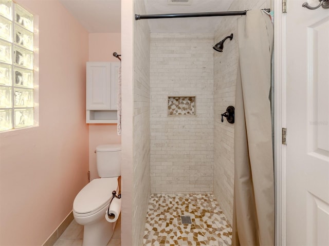 bathroom with tile patterned flooring, curtained shower, and toilet