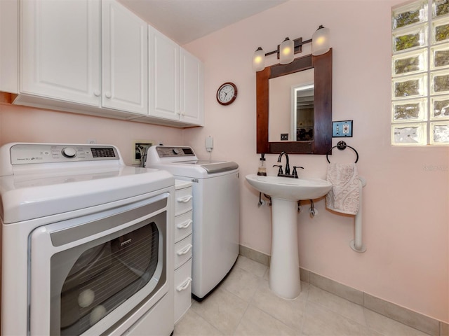 washroom with sink, light tile patterned floors, and independent washer and dryer