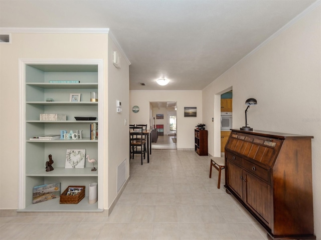 hallway featuring built in shelves and crown molding