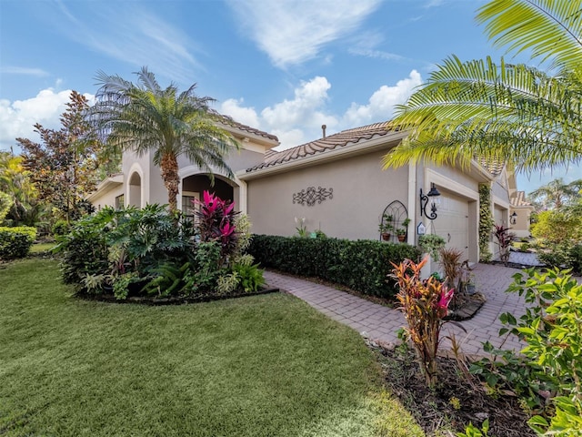 mediterranean / spanish-style house featuring a front lawn and a garage