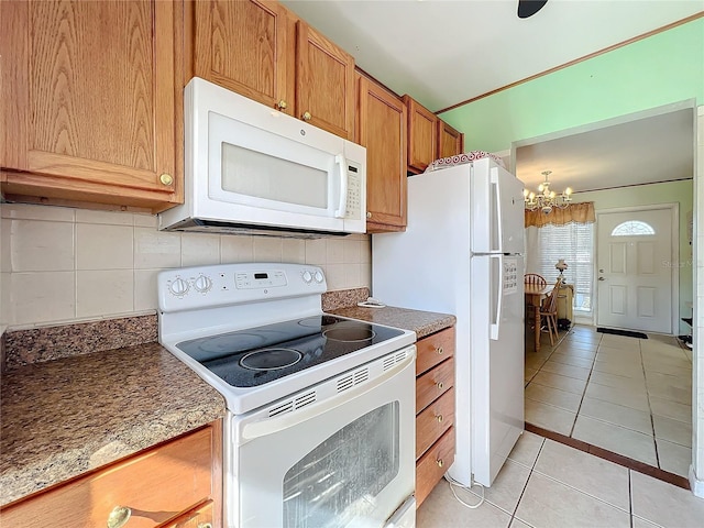 kitchen featuring tasteful backsplash, light tile patterned floors, white appliances, and a notable chandelier