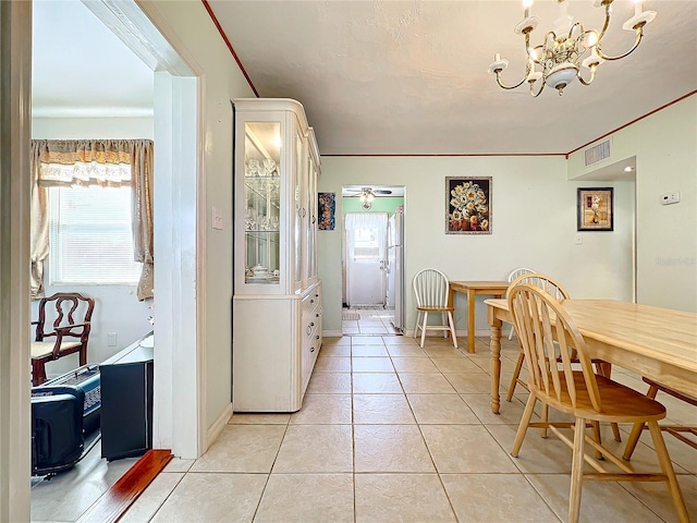 dining space with ceiling fan with notable chandelier and light tile patterned flooring