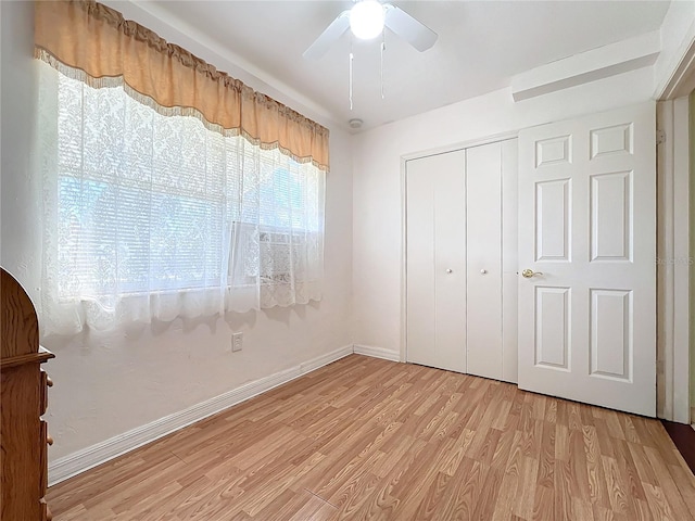 unfurnished bedroom featuring a closet, light hardwood / wood-style flooring, and ceiling fan