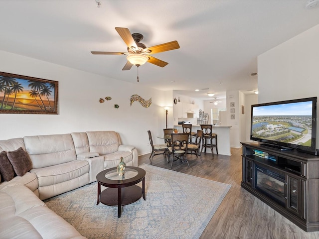 living room with ceiling fan and dark hardwood / wood-style flooring