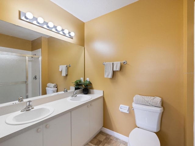 bathroom with vanity, toilet, and a shower with door