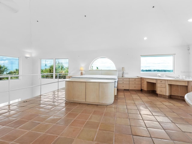 kitchen featuring light brown cabinets, light tile patterned floors, a kitchen island, and sink