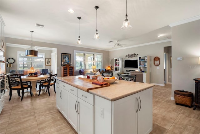 kitchen with ceiling fan, white cabinets, pendant lighting, and a kitchen island