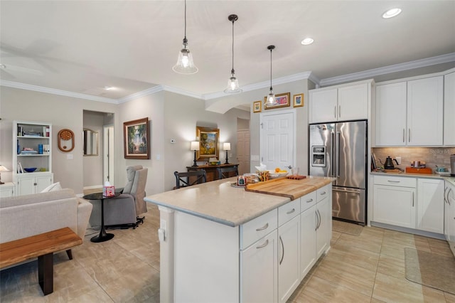 kitchen with high quality fridge, ceiling fan, pendant lighting, white cabinets, and a kitchen island