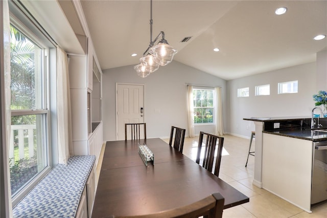 tiled dining space featuring a healthy amount of sunlight, sink, and vaulted ceiling