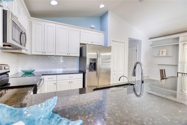 kitchen with white cabinets, stainless steel appliances, and vaulted ceiling