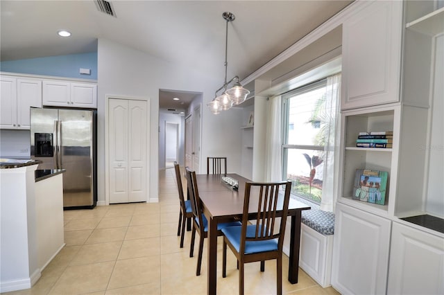 tiled dining space featuring lofted ceiling