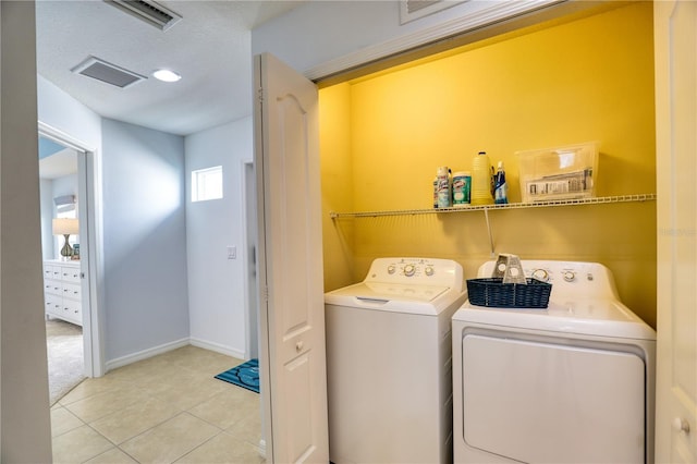 laundry room with washer and clothes dryer and light tile patterned floors