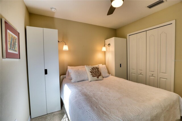 carpeted bedroom featuring ceiling fan and a closet