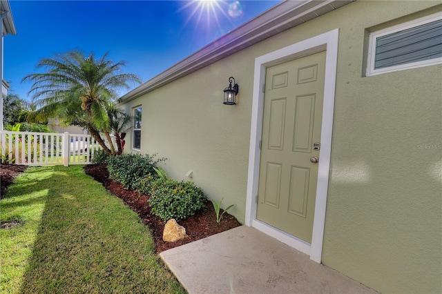 entrance to property featuring a lawn