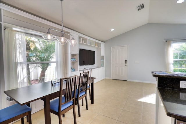 tiled dining room featuring vaulted ceiling