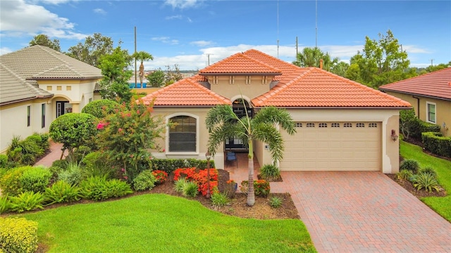 mediterranean / spanish house featuring a garage and a front lawn