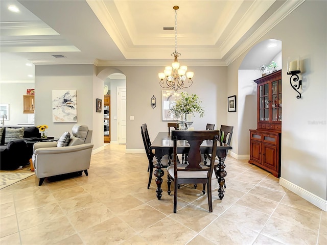 dining area with a notable chandelier, light tile patterned floors, crown molding, and a tray ceiling